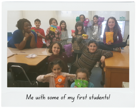 Tenin Terrell, Mini Money Makers | Online Course Digital Product [Smiling teacher stands beside class of elementary students holding their crafts]